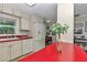 Bright kitchen with white cabinets, red countertops and modern appliances at 4180 W Anthony Rd, Ocala, FL 34475