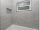 Modern shower with sleek gray tiling, a built-in niche, and a frosted window for natural light at 4180 W Anthony Rd, Ocala, FL 34475