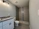 This bathroom features a tiled walk-in shower, granite countertop, and modern lighting at 4424 Sw Carnation Ct, Dunnellon, FL 34431