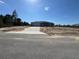 A single-story home with a gray exterior, concrete driveway, a front yard covered with sand, and a blue sky at 4424 Sw Carnation Ct, Dunnellon, FL 34431