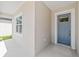 View of a charming home entrance featuring a blue front door and adjacent window with white trim at 4778 Se 25Th Loop, Ocala, FL 34480