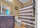 Cozy bathroom featuring a vanity, commode, and a shower with a striped curtain at 5198 Ne 19Th Pl, Ocala, FL 34470