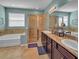Well-lit bathroom boasting double sinks, granite countertops, a glass shower and a soaking tub at 5198 Ne 19Th Pl, Ocala, FL 34470