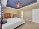Spacious bedroom featuring a trey ceiling, ceiling fan, and an en suite bathroom entrance at 5198 Ne 19Th Pl, Ocala, FL 34470