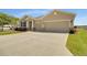 A beautiful home with three-car garage, a wide driveway, and colorful landscaping at 5198 Ne 19Th Pl, Ocala, FL 34470