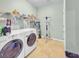 Bright laundry room with tile floor, washer, dryer, and wire shelving at 5198 Ne 19Th Pl, Ocala, FL 34470