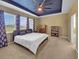 Main bedroom featuring a trey ceiling, carpet flooring, a large window and ample closet space at 5198 Ne 19Th Pl, Ocala, FL 34470