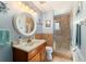 Traditional bathroom with warm lighting, a round mirror, and a glass shower enclosure at 5220 Sw 161St Place Rd, Ocala, FL 34473