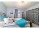 Bright bedroom featuring a metal frame bed, blue accents, and a large window at 5220 Sw 161St Place Rd, Ocala, FL 34473