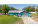 Charming single-story home with gray roof, vibrant blue exterior, and a neatly kept lawn at 5220 Sw 161St Place Rd, Ocala, FL 34473