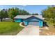 Beautiful single-story home with an attached garage, vibrant blue exterior, and green lawn at 5220 Sw 161St Place Rd, Ocala, FL 34473