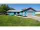 Charming single-story home with a vibrant blue exterior, complemented by a well-manicured lawn at 5220 Sw 161St Place Rd, Ocala, FL 34473