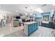 Open-concept kitchen with blue cabinetry, a spacious island, and seamless flow into the living spaces at 5220 Sw 161St Place Rd, Ocala, FL 34473