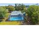An aerial view of a screened-in pool with a gray roof in a backyard setting at 5220 Sw 161St Place Rd, Ocala, FL 34473