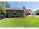 Landscaped backyard with healthy green grass and a view of the neutral colored home at 5484 Sw 30Th Ave, Ocala, FL 34471