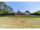 Spacious backyard featuring a black metal fence, lush green lawn, and mature trees surrounding the property at 5484 Sw 30Th Ave, Ocala, FL 34471