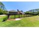 Lush backyard featuring a black metal fence, well-manicured lawn, and mature trees surrounding the property at 5484 Sw 30Th Ave, Ocala, FL 34471