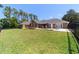 View of the backyard with green grass leading up to the pool area and single-story home at 5484 Sw 30Th Ave, Ocala, FL 34471