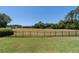 Expansive backyard featuring a well-maintained lawn, mature trees, and a secure black metal fence at 5484 Sw 30Th Ave, Ocala, FL 34471