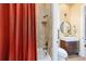 Bright bathroom features tiled shower with orange curtain, toilet, and stylish dark wood vanity at 5484 Sw 30Th Ave, Ocala, FL 34471