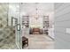 Bright bathroom with tiled shower, wood-look tile, bench, chandelier, and built-in cabinets at 5484 Sw 30Th Ave, Ocala, FL 34471