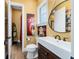 Charming bathroom featuring a square sink, wooden cabinets, toilet, and whimsical cow artwork at 5484 Sw 30Th Ave, Ocala, FL 34471