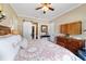 Bedroom features a ceiling fan, hardwood floors, and barn door access to the laundry room at 5484 Sw 30Th Ave, Ocala, FL 34471