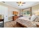 Comfortable bedroom features a ceiling fan, hardwood floors, natural light, and neutral tones at 5484 Sw 30Th Ave, Ocala, FL 34471