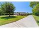 Traditional home with a long driveway, manicured lawn, and mature trees, offering curb appeal and privacy at 5484 Sw 30Th Ave, Ocala, FL 34471