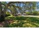 Charming home featuring a circular driveway, lush lawn, mature shade trees, and elegant architectural details at 5484 Sw 30Th Ave, Ocala, FL 34471
