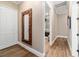 Hallway with wood floors leads to bathroom featuring an ornate mirror and stylish neutral decor at 5484 Sw 30Th Ave, Ocala, FL 34471