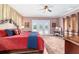 Bright main bedroom featuring French doors with pool view, ceiling fan, and decorative rug at 5484 Sw 30Th Ave, Ocala, FL 34471