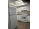 Bright kitchen featuring white cabinets, laminate countertops, and stainless steel appliances at 571 Midway Trak # J202, Ocala, FL 34472