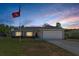 Charming one-story home with manicured lawn and two-car garage, under a beautiful sunset sky at 5899 Pecan Rd, Ocala, FL 34472