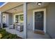Inviting front porch with gray decor, including a 'Welcome' mat and decorative wreath on the door at 5899 Pecan Rd, Ocala, FL 34472