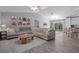 Open concept living room with vaulted ceilings, wood flooring, large sofa, and natural light at 5899 Pecan Rd, Ocala, FL 34472