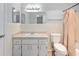 A full bathroom with tiled walls, a vanity, a toilet, and a shower with peach colored curtain at 614 Third Ave, Lady Lake, FL 32159