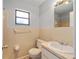 Bathroom featuring neutral color tile, toilet, vanity and mirror at 614 Third Ave, Lady Lake, FL 32159