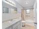 A full bathroom featuring tile walls, a vanity, a toilet, and a shower/tub combo with a grab bar at 614 Third Ave, Lady Lake, FL 32159