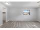 Bright bedroom with light gray walls, wood-look flooring, and a window with a view of the outside at 614 Third Ave, Lady Lake, FL 32159