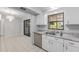 Kitchen and dining area shows appliances, white cabinets and updated counters at 614 Third Ave, Lady Lake, FL 32159