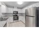 Kitchen features stainless steel appliances, tile floors, and white cabinets at 614 Third Ave, Lady Lake, FL 32159