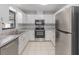 Kitchen features stainless steel appliances, tile floors, and white cabinets at 614 Third Ave, Lady Lake, FL 32159