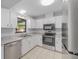 Kitchen features stainless steel appliances, tile floors, and white cabinets at 614 Third Ave, Lady Lake, FL 32159