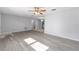 Large, freshly painted living room featuring stylish gray flooring and a ceiling fan at 614 Third Ave, Lady Lake, FL 32159