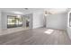 Spacious living room with sleek gray flooring, a ceiling fan, and access to the screened patio at 614 Third Ave, Lady Lake, FL 32159