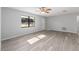 Open living area featuring new flooring, fresh paint, ceiling fan and a decorative door at 614 Third Ave, Lady Lake, FL 32159