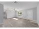 Bright and airy living room featuring stylish gray flooring, a ceiling fan, and a large window at 614 Third Ave, Lady Lake, FL 32159