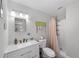 Stylish bathroom with a single sink vanity, a mirror, and a shower with light pink shower curtain at 6318 Nw 52Nd Ave, Ocala, FL 34482