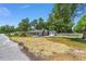 Charming single-story home with a driveway, landscaping, and a detached garage or shed at 6318 Nw 52Nd Ave, Ocala, FL 34482